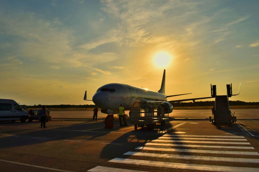 An airplane sits on the tarmac at sunset.