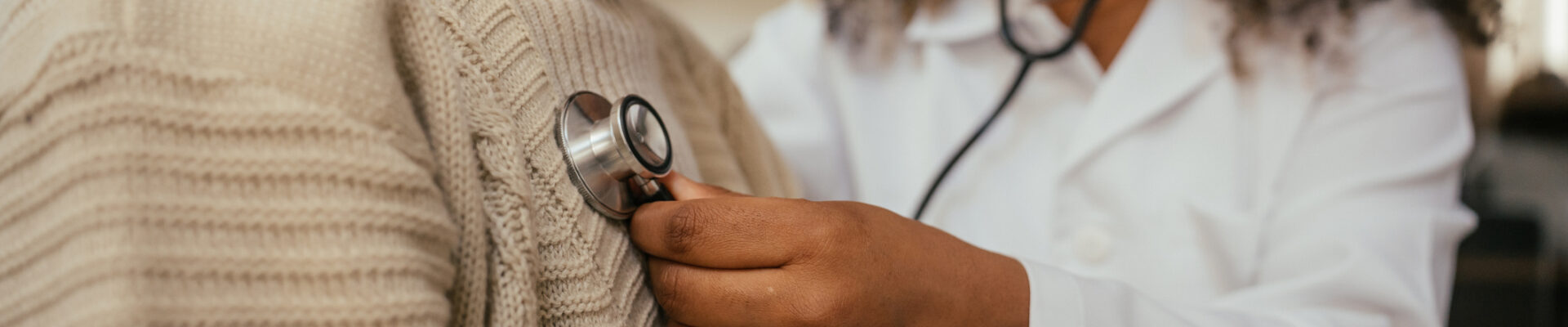 Doctor examining an elderly patient with a stethoscope.