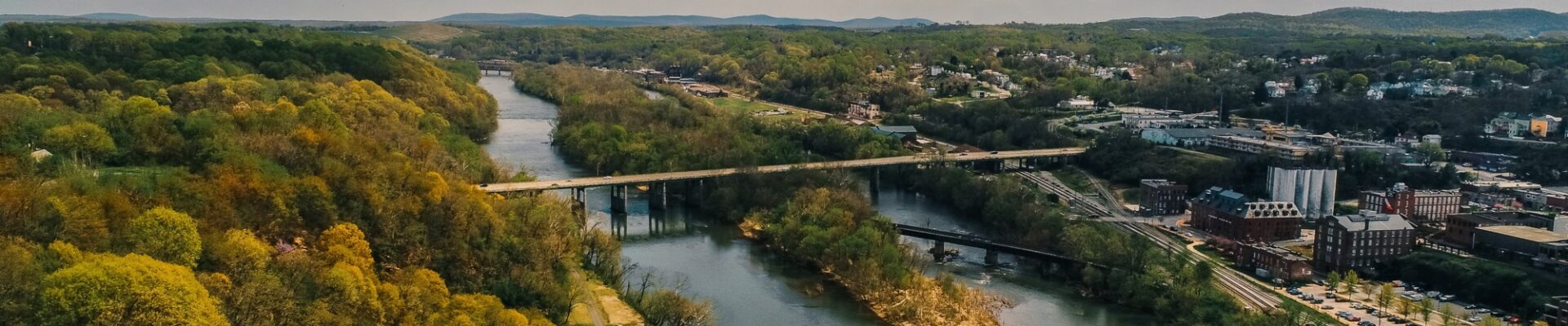 Aerial of a river flanked by the City of Lynchburg, VA