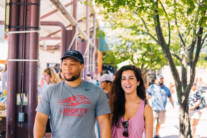 Couple walks down a small town city street in summer