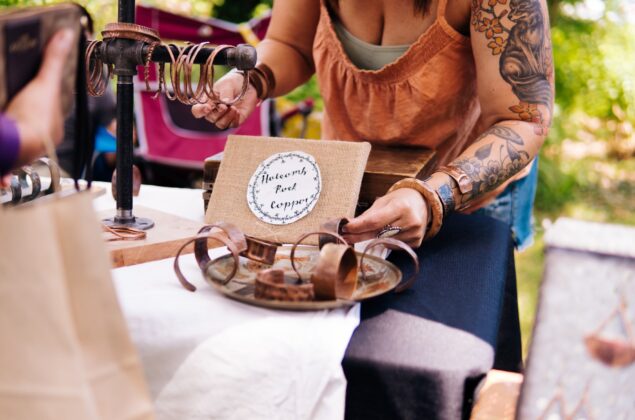 Woman looks at jewelery at a fair table