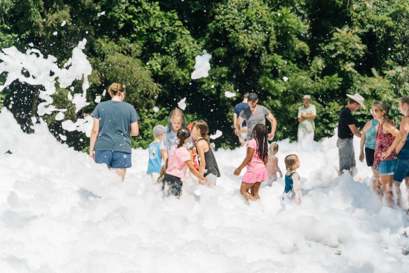 Children play in bubbles at a street fair