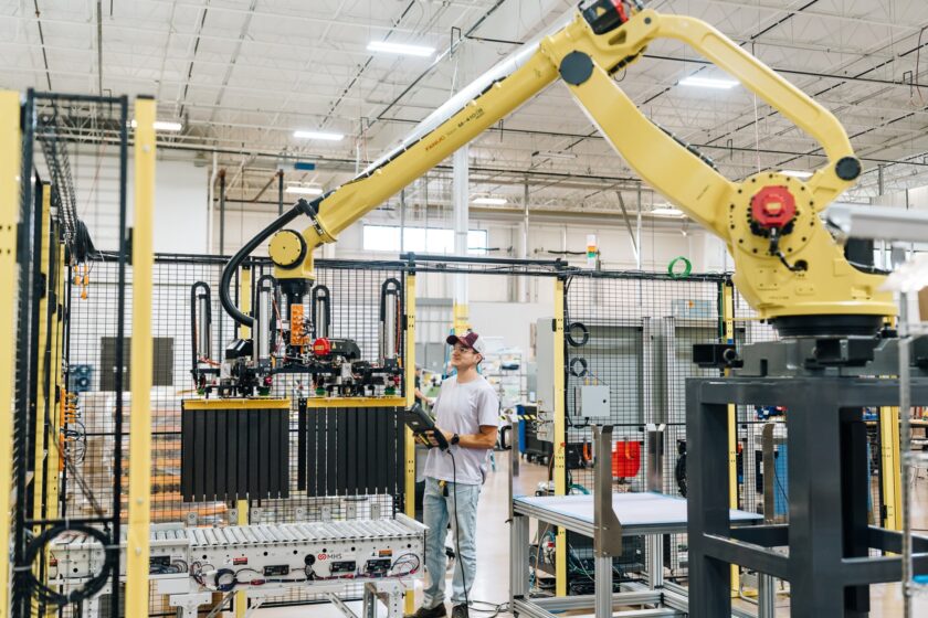 A robotics employee works in an automation warehouse.