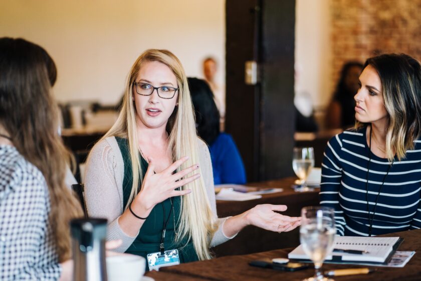 Several young women speak at a table at a Young Professionals in Central Virginia event.