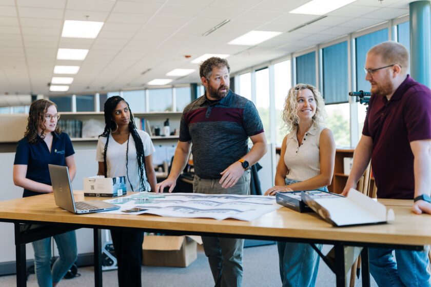 Colleagues standing working around a table