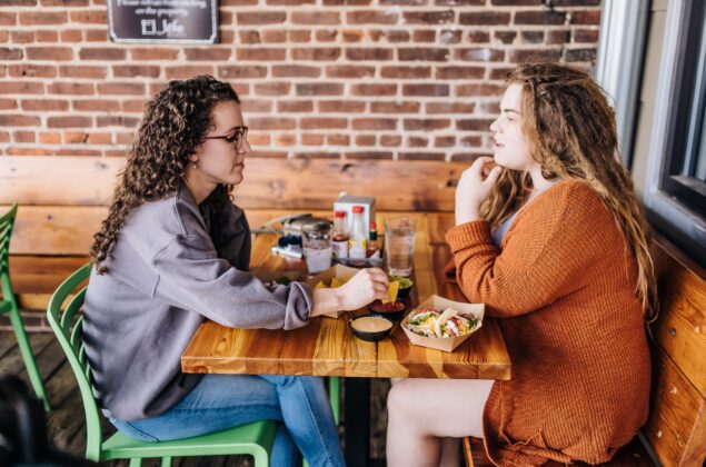 Two people share a meal of nachos and tacos.