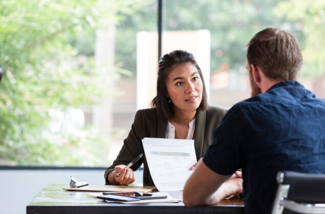 Two professionals discussing a document at a table.