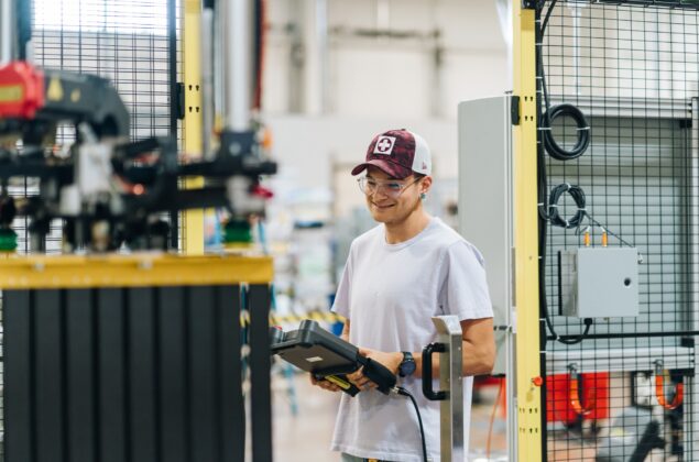 A young robotics employee tests new machinery.